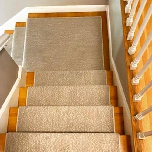 Custom stair runner installation by Sunshine Carpet & Flooring in North Chelmsford, MA – classic patterned runner on hardwood stairs