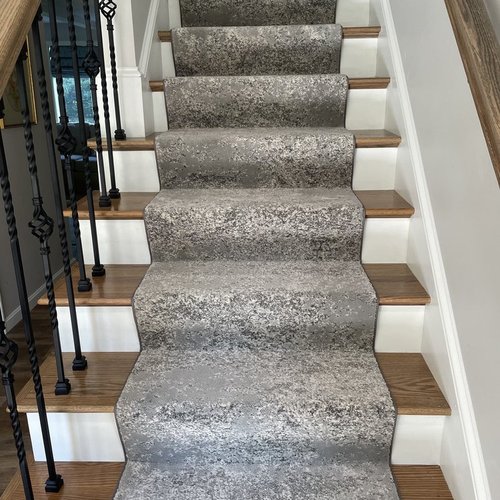 Custom stair runner installation by Sunshine Carpet & Flooring in North Chelmsford, MA – classic patterned runner on hardwood stairs