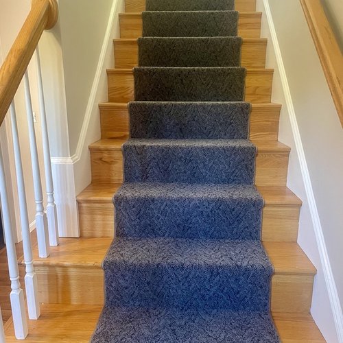 Custom stair runner installation by Sunshine Carpet & Flooring in North Chelmsford, MA – classic patterned runner on hardwood stairs