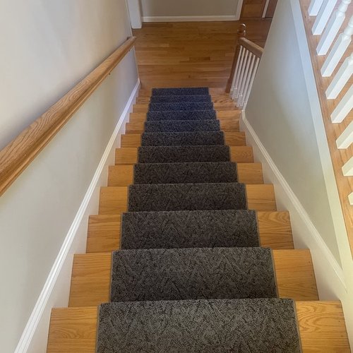 Custom stair runner installation by Sunshine Carpet & Flooring in North Chelmsford, MA – classic patterned runner on hardwood stairs