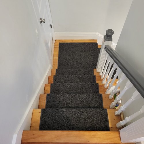 Custom stair runner installation by Sunshine Carpet & Flooring in North Chelmsford, MA – classic patterned runner on hardwood stairs