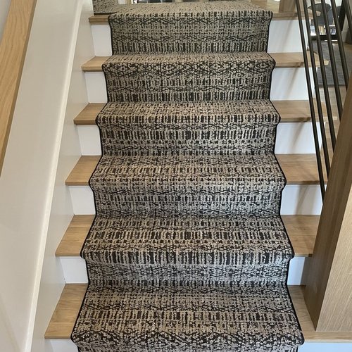 Custom stair runner installation by Sunshine Carpet & Flooring in North Chelmsford, MA – classic patterned runner on hardwood stairs