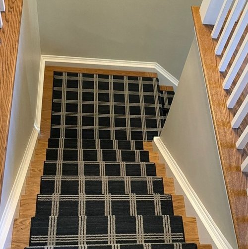 Custom stair runner installation by Sunshine Carpet & Flooring in North Chelmsford, MA – classic patterned runner on hardwood stairs