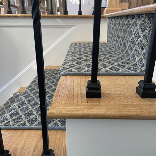 Custom stair runner installation by Sunshine Carpet & Flooring in North Chelmsford, MA – classic patterned runner on hardwood stairs