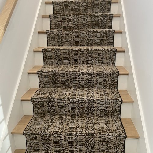 Custom stair runner installation by Sunshine Carpet & Flooring in North Chelmsford, MA – classic patterned runner on hardwood stairs