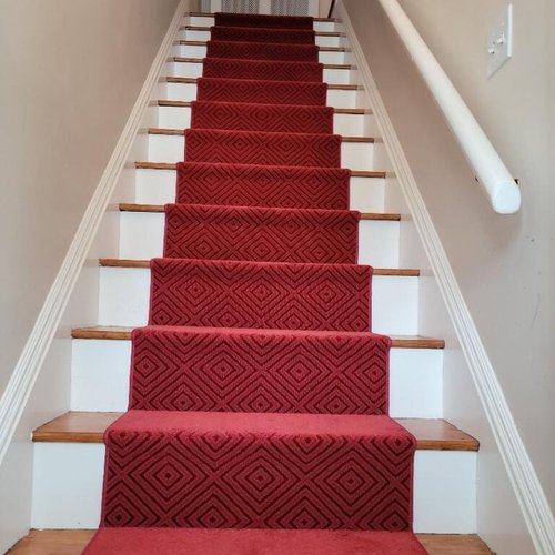 Custom stair runner installation by Sunshine Carpet & Flooring in North Chelmsford, MA – classic patterned runner on hardwood stairs